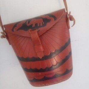 All leather bucket crossbody bag, fasten with latch. Designed with elephant